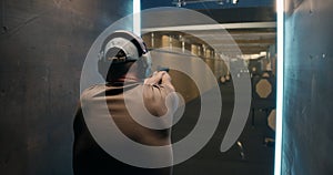 Anonymous man shooting pistol at target