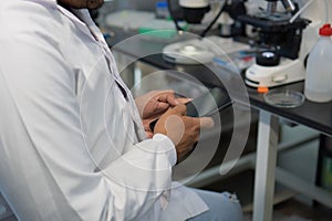anonymous man using mobile phone in modern laboratory