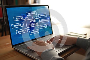 Anonymous person typing on laptop with web design program displayed on screen. UI UX website layout design