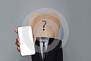 Anonymous person wearing blank empty paper bag on head and phone with empty display. App and cocial media concept
