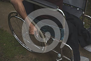 An anonymous polio survivor pushes the handrims of his wheelchair