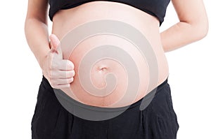 Anonymous pregnant woman belly and hand showing like gesture