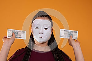 An anonymous woman stands and pulls her hand in with paper banknotes with the face value of one hundred Polish zlotys