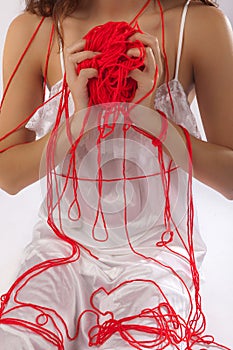 Anonymous woman white silk nightie holding red ball of wool