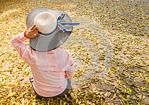 Anonymous women wearing blue hats sit alone.