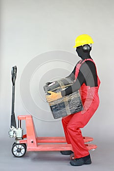 Anonymous worker lifting  heavy package. Profile view.