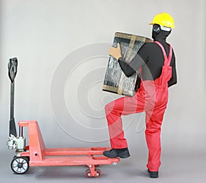 Anonymous worker lifting  heavy package. Profile view.