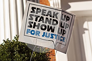 An anonymous yard sign that says: `Stand up, speak up, show up for justice`