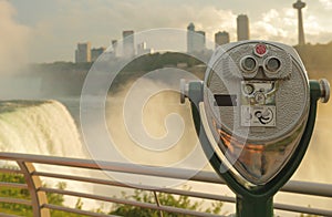 Anoramic View of Niagara Falls at Sunset with binoculars in foreground.