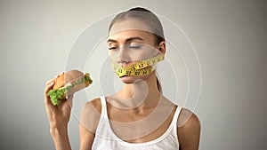 Anorexic girl ties mouth with tape, fights with temptation to eat burger