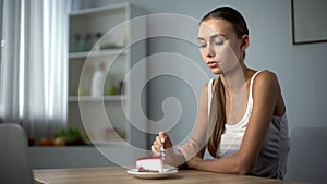 Anorexic girl trying to eat cake, inability to digest food, health problems