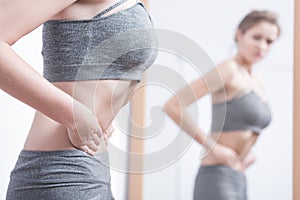 Anorexic woman watching herself in a mirror