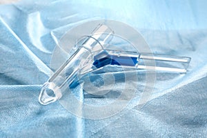 Anoscope on light blue fabric. Hemorrhoid treatment