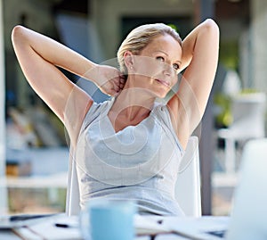 Another great day for business. a contented businesswoman leaning back with her hands behind her head.