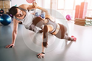 Another picture of two people standing in a side plank position on one hand and holding each other with the other hands