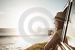 Another summer, another road trip. a young woman enjoying a road trip along the coast.