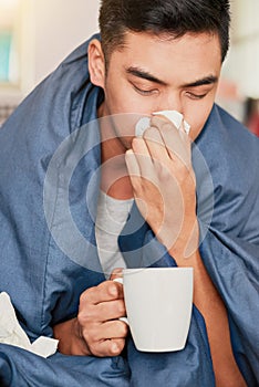 Another victim of the man flu. a young man with a cold recuperating at home. photo