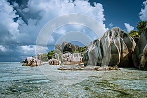 Anse Source d'Argent - most famous paradise tropical beach. Bizarre granite rocks against beautiful white clouds. La