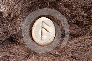 Ansuz Nordic stone rune on animal fur. Letter Aesc of the Viking alphabet