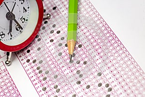 Answer sheet with pencil and alarm clock