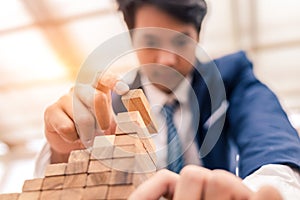 Ant eye view Male hand stacking wooden blocks. Business development and growth concept