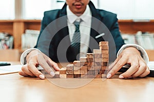 Ant eye view Male hand stacking wooden blocks. Business development and growth concept