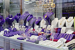 Shop window in the tourist part of the city with a lot of all kinds of jewelry made of gold and silver