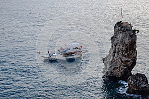 The yacht sails along the rocky coast, an excursion the coast of Antalya