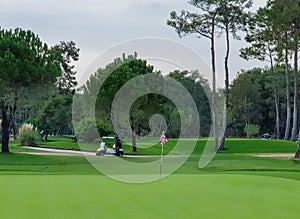 Golf courses with paths that drive Golf cars, a red flag stands in the hole photo