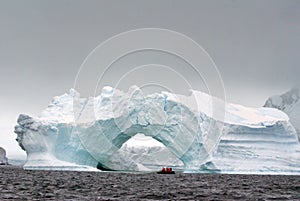 Antarctic cruise launch by an arched iceberg Antarctica