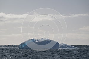 Antarctic icebergs pn a clear day with an amazing sky as background