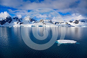 Antarctic landscape with mountains, glacier and ice floe oin dark blue water of Lemaire Channel near Paradise Bay, Antarctica