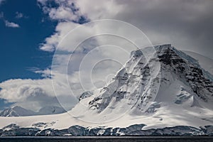 Antarctic Mountain; clouds, blue sky in background.