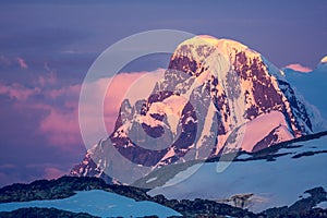 Antarctic mountain on the colorful sky background.