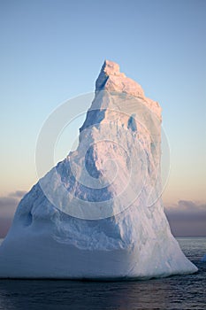 Antarctica blue iceberg in sunset