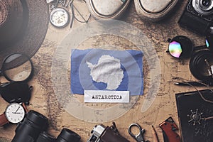 Antarctica Flag Between Traveler`s Accessories on Old Vintage Map. Overhead Shot