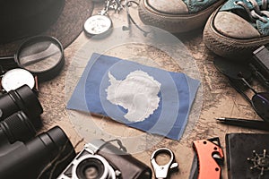 Antarctica Flag Between Traveler`s Accessories on Old Vintage Map. Tourist Destination Concept