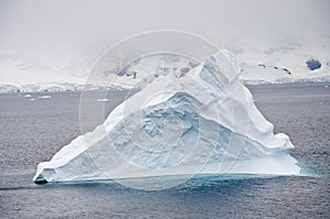 Antarctica - Non-Tabular Iceberg Drifting In The Ocean