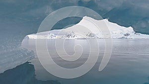 Antarctica shot through iceberg arch.