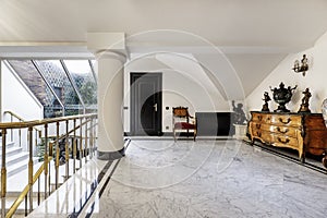 Antechamber next to the stairwell of a luxury home with marble floors and skylight with terrace