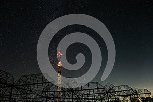 Antenna array of radio astronomy telescope on background of starry dark night sky