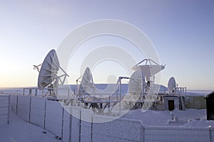 Antenna covered by hoarfrost against blue sky