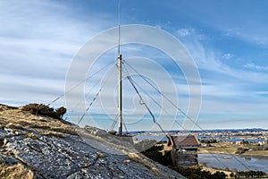 Antenna post on top of a hill in Tananger suburb and Hafsfjord fjord view on background