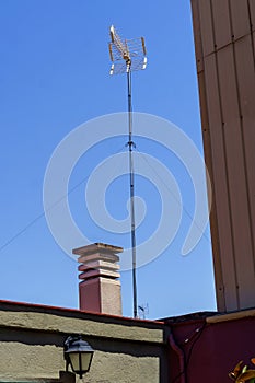 Antenna for television reception and chimney on the roof of a house