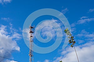 Antenna tower with blue sky and cloud background.