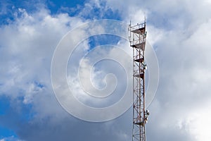 Antenna tower with blue sky and cloud background.