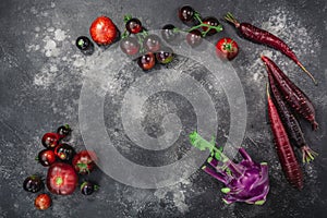 Anthocyanin-rich vegetables on dark textured backdrop,  top view