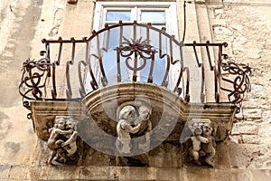 Anthropomorphic Stone figures under the balcony of La Rocca palace .Ragusa Ibla Sicily Italy