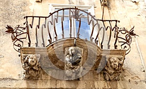 Anthropomorphic Stone figures under the balcony of La Rocca palace. Ragusa Ibla Sicily Italy