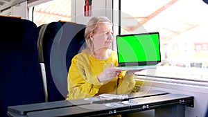anti-advertising a woman holding a laptop with a green chromakey screen in her hands shows her thumb down, contorting